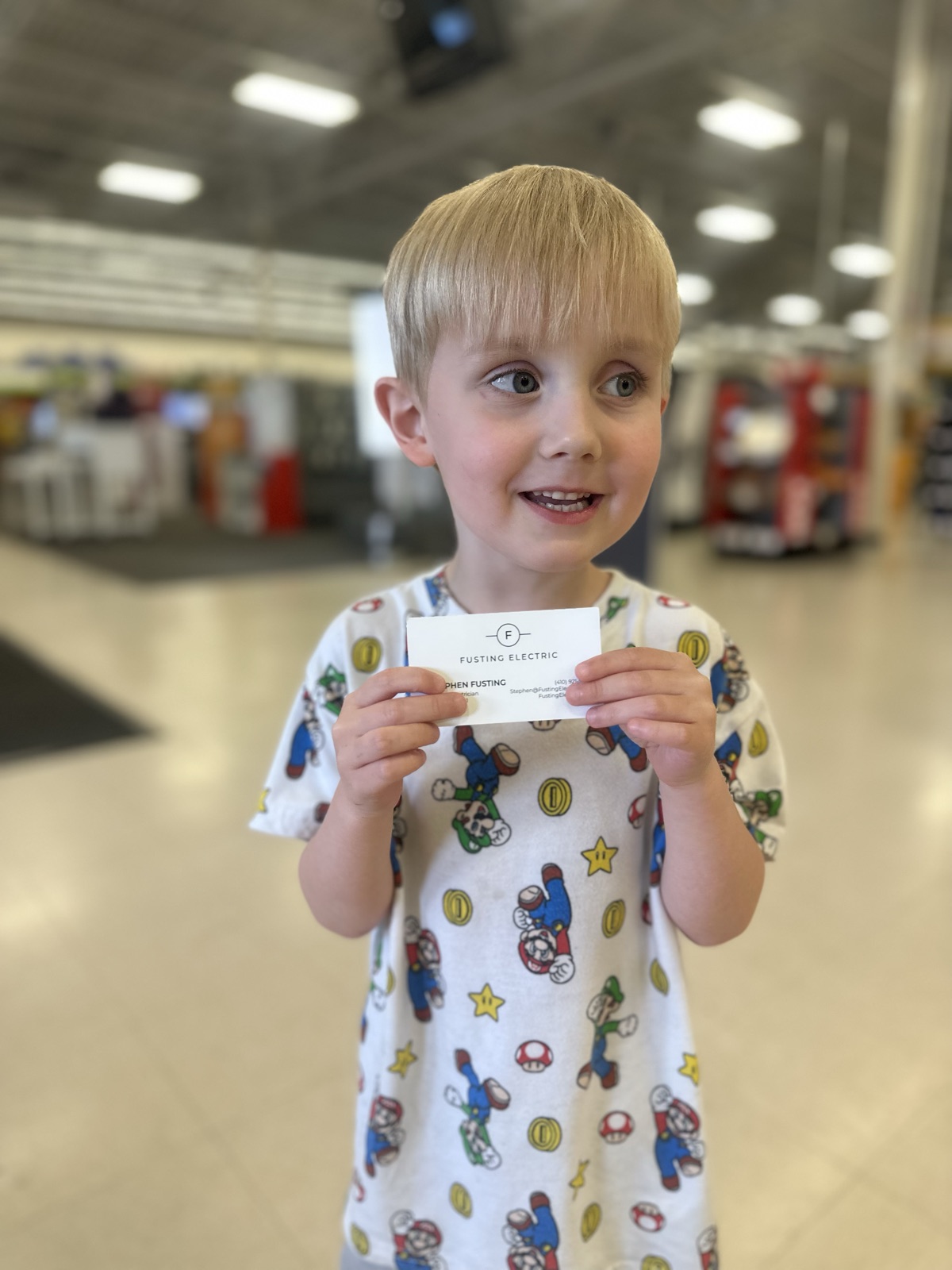 Colton holding a Fusting Electric business card