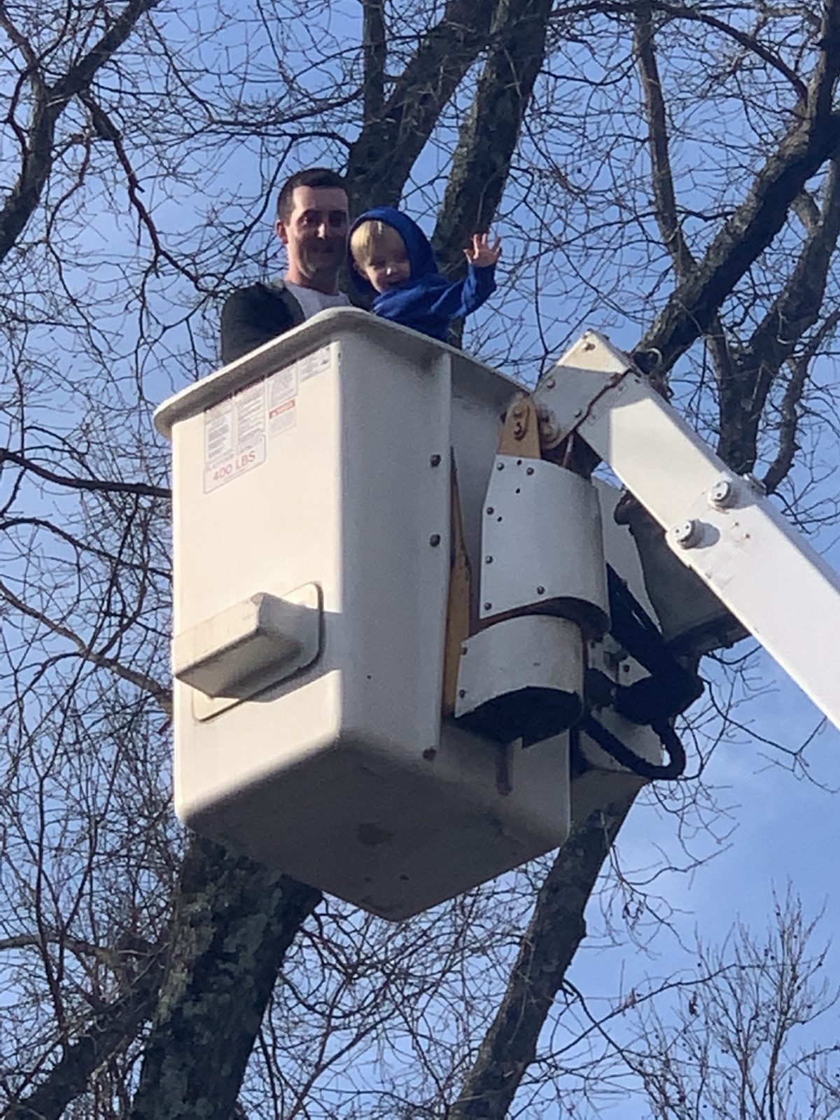 Stephen Fusting and Colton standing together in a bucket truck